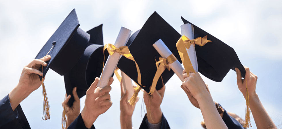 A Group Holding Graduation Caps And Diplomas In The Air